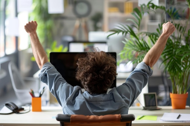 A man is sitting at a desk with a computer monitor in front of him