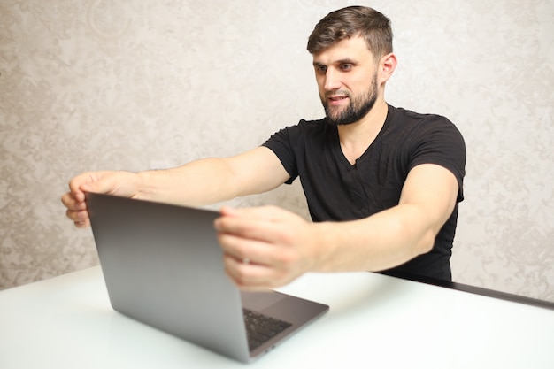 a man is sitting in front of a laptop