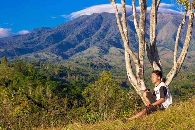 A man is sitting on a hill