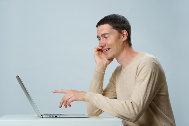 Man is sitting at table and using laptop for communication in chat or video chat Social media concept