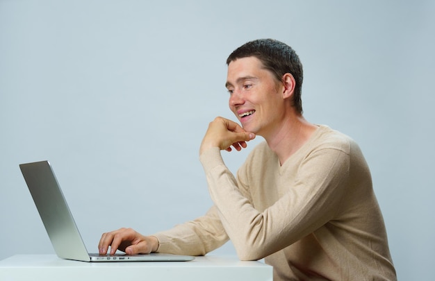 Man is sitting at table and using laptop for communication in chat or video chat Social media concept