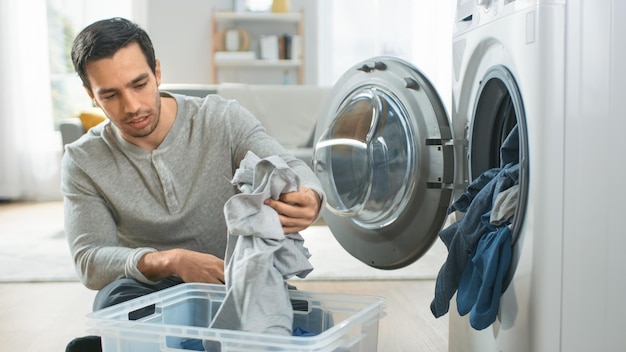 Premium Photo | A man is sorting clothes in a laundry machine.