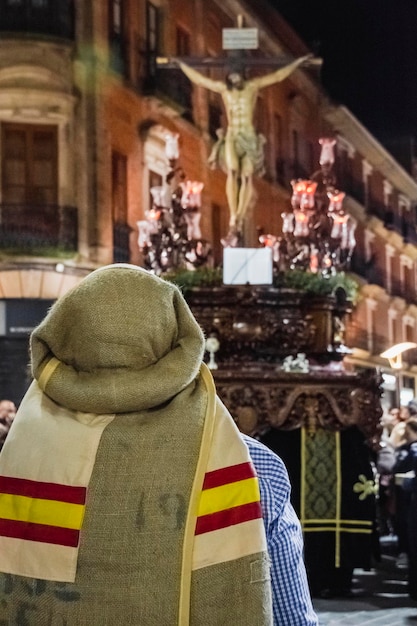 Foto un uomo è in piedi davanti a una statua che indossa un cappello