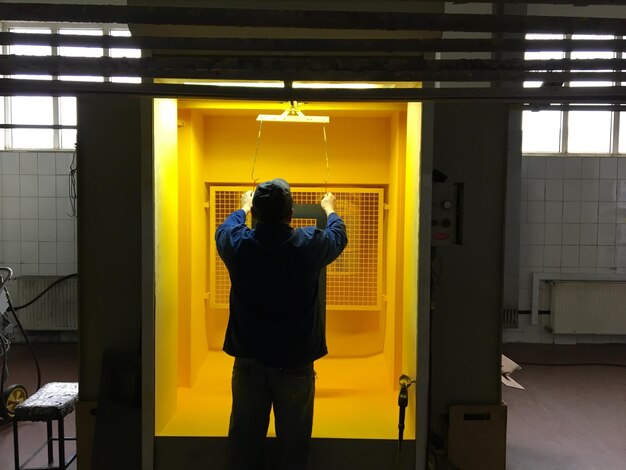 A man is standing in a yellow cage with the number 1 on it.