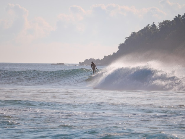 The man is surfing on his small wave in the ocean