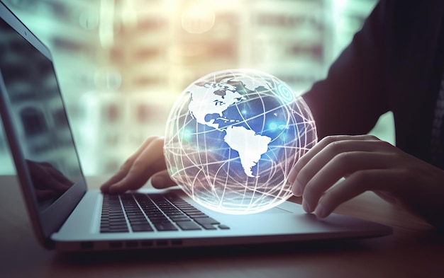 A man is typing on a laptop with a globe on the screen.