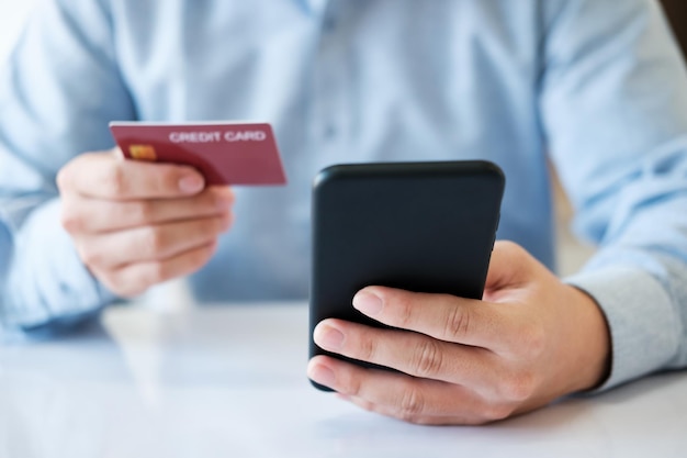 A man is using his phone to pay for a credit card