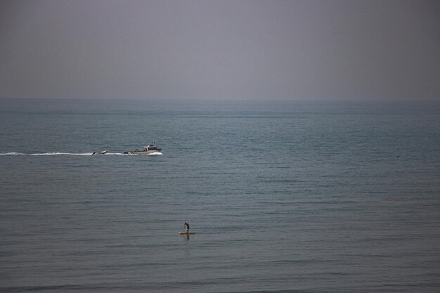 Photo a man is in the water with a surfboard in the water.