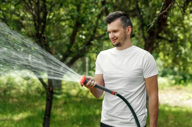 男がホースから水をまく