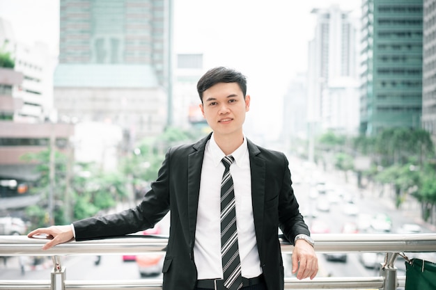 Photo a man is wearing a black suit, white shirt and necktie.