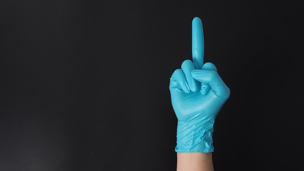 Мужчина носит синие латексные перчатки и делает знак рукой средним пальцем. Используйте их, когда хотите сказать «пошел на хуй».