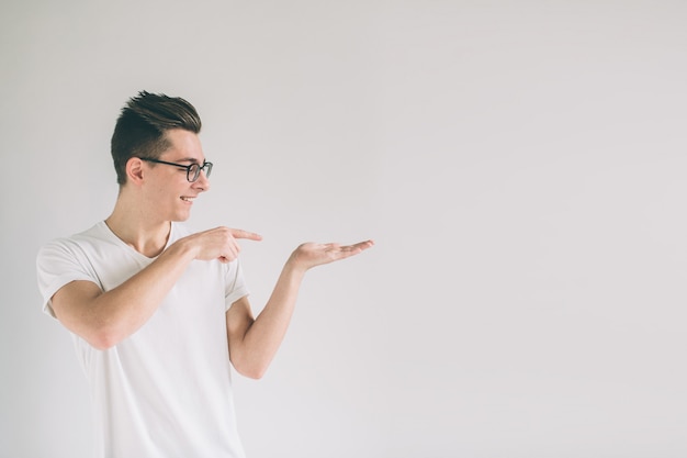 Man is wearing glasses holding something imaginary in one hand