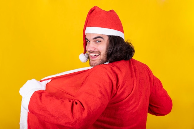 Photo a man is wearing santa claus suit he smiles and looks towards the viewer with a mischievous look