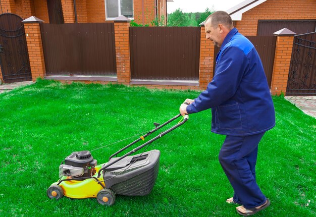 The man is working in the garden Mowing grass with a lawn mower