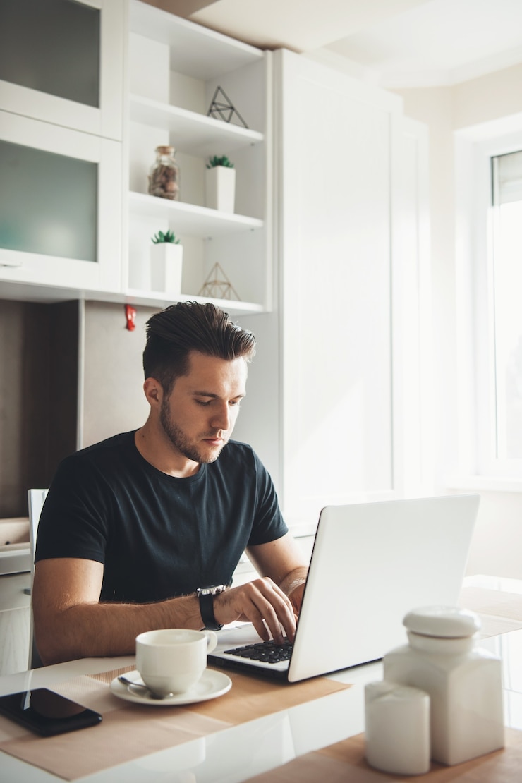 Photo man is working remotely from home using a laptop