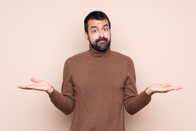 Man over isolated  having doubts while raising hands