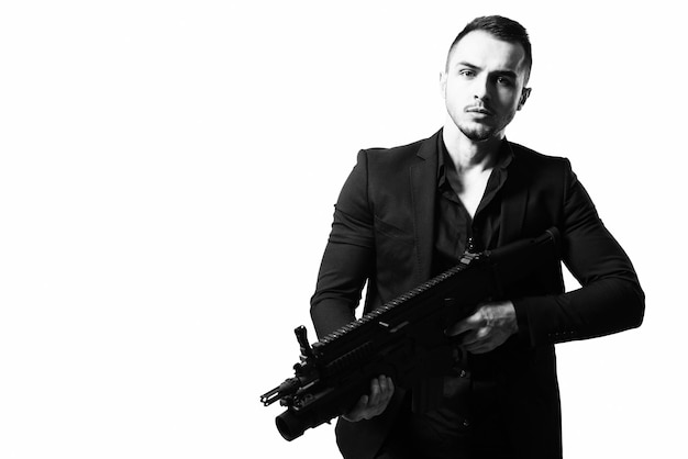 Man Isolated on a White Background With a Handgun as He Turns and Aims Off Camera