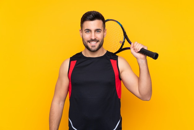 man over isolated yellow wall playing tennis