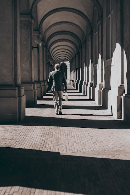 Man in jacket under arcades