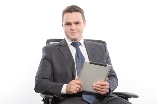 Man in a jacket sitting on a chair and holding with the tablet