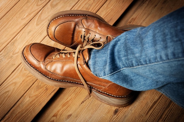 Man in jeans wearing old brown leather shoes