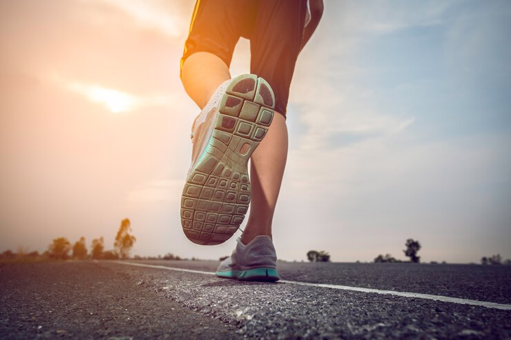 Foto man joggen op een weg met de zon.