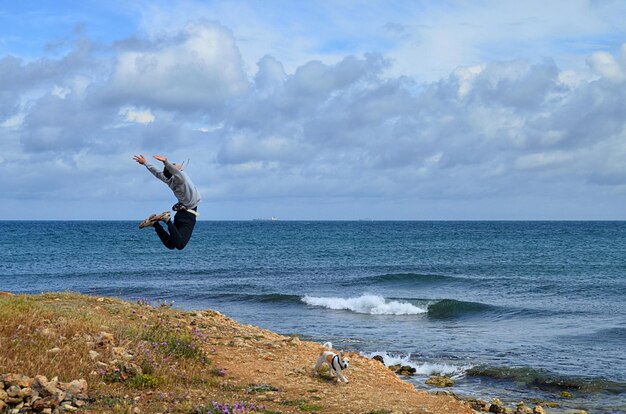 写真 海の背景にジャンプする男