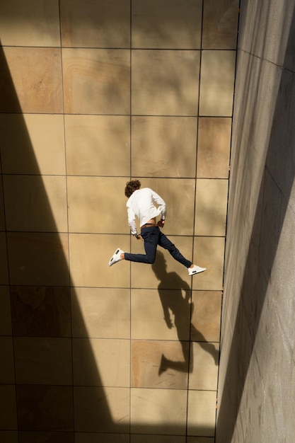 Foto uomo che salta contro il pavimento di piastrelle
