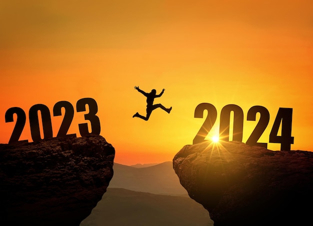 Man jumping on cliff 2024 over the precipice at amazing sunset New Year's concept Symbol of starting and welcome happy new year 2024 People enters the year 2024 creative idea