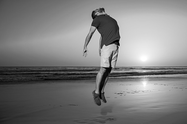 Man jumping on nature silhouette in the sunset amazing view on sunset beach