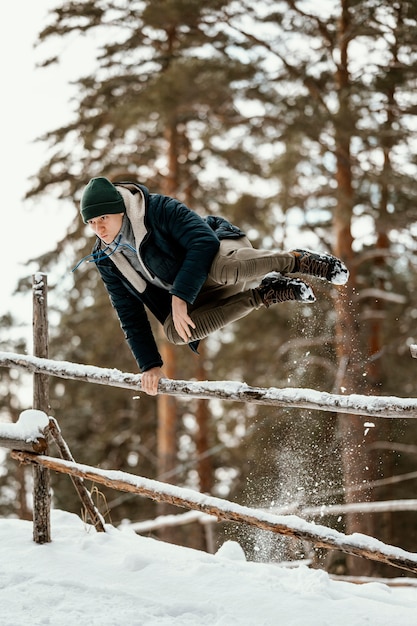 Foto l'uomo che salta all'aperto in inverno