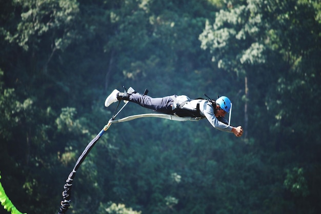 Photo a man jumps from a cliff into the abyss