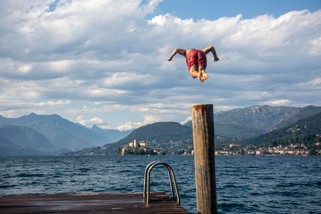 男がイタリアのオルタ湖の水に飛び込む