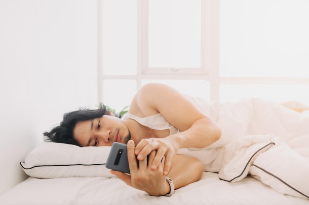Man just wake up and use smartphone first thing in the morning