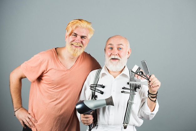 Man kapper met gereedschap voor kleurstof tot man haar professionele kapper maakt stijlvol mannenkapsel oud en ...