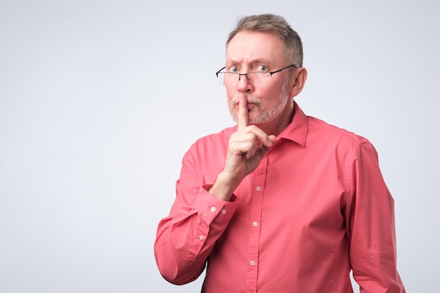 Man keeps finger on lips tries to keep secret