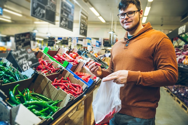 Man kiest rode peper in de markt. winkelconcept