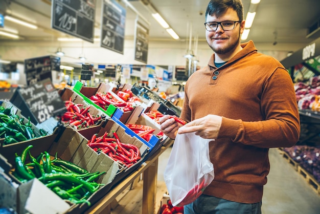 Man kiest rode peper in de markt. winkelconcept