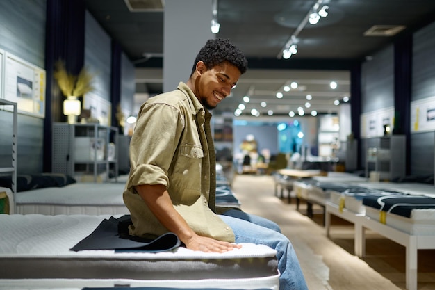 Man kiezen matras zittend op winkel bed