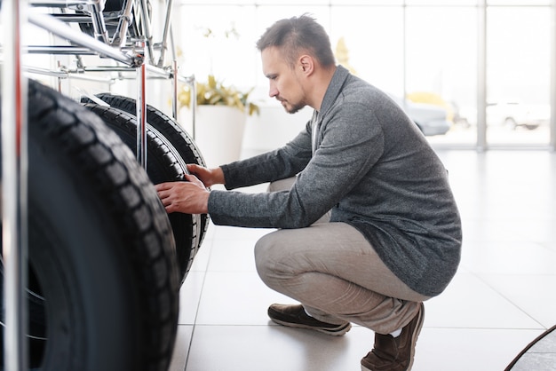 Man kiezen van banden voor nieuwe auto in showroom.