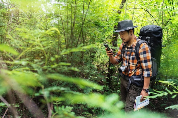 Man kijkt naar camera in het bos.