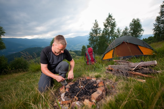 Man kindling firewood on the hill