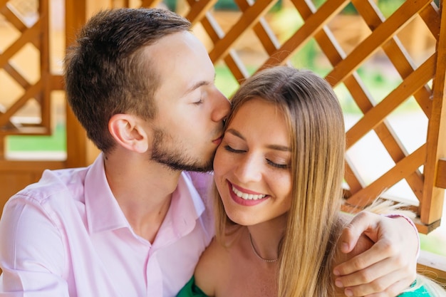 Man kisses his girlfriend in nature and hugs