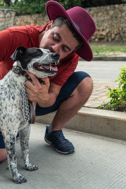 屋外で彼の犬にキスする男