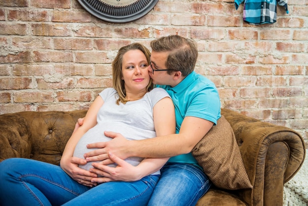 Foto un uomo che bacia la sua donna incinta un uomo che baccia la sua moglie incinta sono seduti