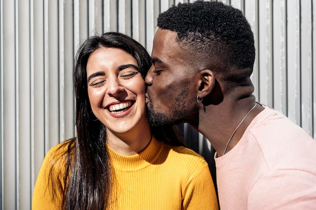 Man kissing woman against wall