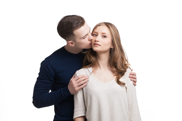 Man kissing woman in cheek while she looking at camera