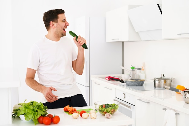 Foto uomo in cucina a cantare