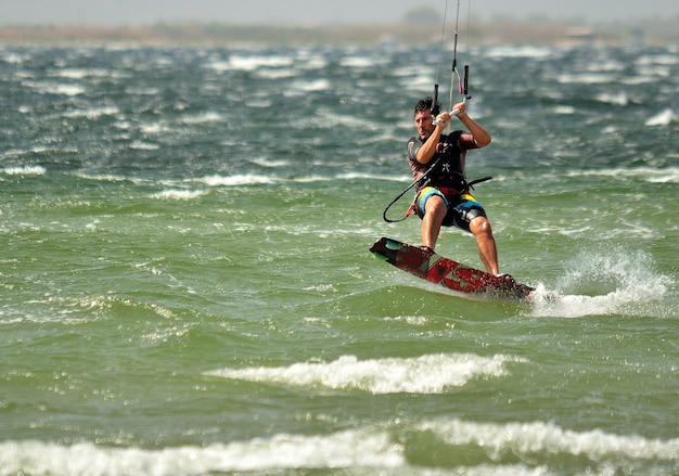 Foto uomo che fa kiteboard in mare