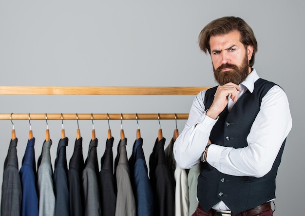 Foto man kleding in boetiek man met pak kleermaker in zijn atelier knappe bebaarde mode man in klassiek kostuum pak man in op maat gemaakt pak presenteren dure smoking een andere klant